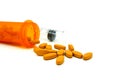 Many yellow pills out of the orange bottle of medicine and blurred plastic injection with copy space isolated on white background Royalty Free Stock Photo