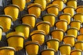 Many yellow plastic pots for plants and seedlings hanging in a row, spring gardening preparation and planting concept