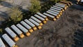 Many yellow school buses are parked in rows in a dirt lot Royalty Free Stock Photo