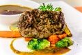 Manzo grilled beef steak with grilled tomato, baby cabbage, carrot and gravy on the side Royalty Free Stock Photo