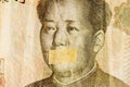 Mao portrait, leader of China with closed mouth on a banknote of Chinese Yuan, as a symbol of the instability of economy