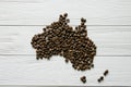 Map of the Australia made of roasted coffee beans laying on white wooden textured background Royalty Free Stock Photo