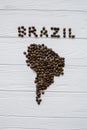 Map of the Brazil made of roasted coffee beans laying on white wooden textured background Royalty Free Stock Photo