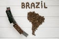 Map of the Brazil made of roasted coffee beans laying on white wooden textured background with toy train Royalty Free Stock Photo