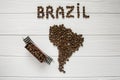 Map of the Brazil made of roasted coffee beans laying on white wooden textured background with toy train Royalty Free Stock Photo