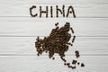 Map of the China made of roasted coffee beans laying on white wooden textured background Royalty Free Stock Photo