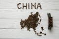 Map of the China made of roasted coffee beans laying on white wooden textured background with toy train Royalty Free Stock Photo