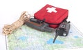 Map, gps navigator, portable radio, rope and first aid kit on a