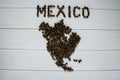 Map of the Mexico made of roasted coffee beans laying on white wooden textured background Royalty Free Stock Photo
