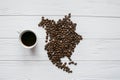 Map of the North America made of roasted coffee beans laying on white wooden textured background with cup of coffee Royalty Free Stock Photo