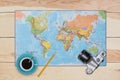 Map, old camera, cup of coffee and pencil laying on wooden desk. Necessary equipment of traveler or tourist. Top view of traveler Royalty Free Stock Photo