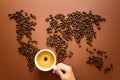 Map of the world made of roasted coffee beans on brown paper background.