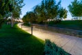 Maple alley in French garden in public landscape city park Krasnodar or Galitsky park . Wooden circular brown benches around maple Royalty Free Stock Photo