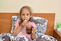 A maple girl puts a pill in her mouth and drinks water. Self-treatment