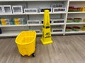 Mop bucket and caution wet floor sign warning customers at a Kohls Department Store Royalty Free Stock Photo