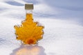 Maple Leaf Shaped Bottle Filled with Golden Maple Syrup Sitting on Fresh Snow #2