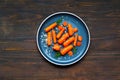Maple-Roasted Carrots in plate on wooden background. Creative copy space