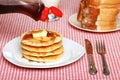 Maple Syrup being poured on a stack of pancakes