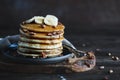 Maple syrup pouring onto pancakes against dark background Royalty Free Stock Photo