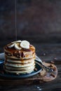 Maple syrup pouring onto a stack of pancakes against dark background Royalty Free Stock Photo