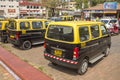 Indian taxi stand with black yellow cars