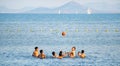 Mar menor, Murcia, Spain, August 5, 2019: Group of happy cute kids play volleyball in water at the beach