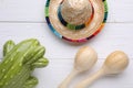 Maracas, toy cactus and sombrero hat on white wooden table, flat lay. Musical instrument Royalty Free Stock Photo