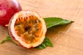Maracuja cut in half and whole with leaf on wooden background. Passion fruit with fruit yellow juice and seeds