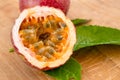 Maracuja cut in half and whole with leaf on wooden background. Passion fruit with fruit yellow juice and seeds