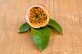 Maracuja cut in half and whole with leaf on wooden background. Passion fruit with fruit yellow juice and seeds