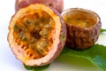 Maracuja cut in half and whole in small glass container peel of the fruit with leaf on white background. Passion fruit yellow with