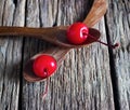 Maraschino cherry vibrant on wooden spoon and old table background Royalty Free Stock Photo