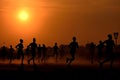 Marathon black silhouettes of runners on the sunrise, neural network generated image Royalty Free Stock Photo