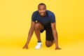 African Male Runner Standing In Crouch Start Position, Yellow Background Royalty Free Stock Photo