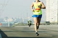 Marathon running in the morning light . Running on city road. Athlete runner feet running. Young woman runner running on city