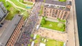 Marathon running race, aerial view of start and finish line with many runners from above, road racing, sport competition