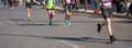 Marathon running race, runners running on city roads, detail on legs