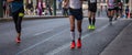 Marathon running race, runners running on city roads, detail on legs