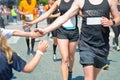 Marathon running race,runners support on road race, child`s hand giving highfive, kid supporting athletes who run