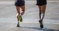 Marathon running race, two runners on city roads, detail on legs