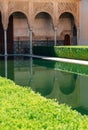 Marble capitals and stucco decoration of the portico in Court of Myrtles with internal pool in Comares Palace Alhambra, Andalusia Royalty Free Stock Photo