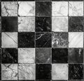 The marble chess board has a background with a tile pattern that is checkered in black and white Royalty Free Stock Photo
