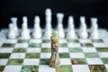 Marble chess board from white and green marble. Black chess king on chessboard against white chess pieces. Concept one against all Royalty Free Stock Photo