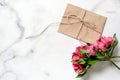 Marble desk with pink flowers, postcard, kraft envelope, twine, cotton branch Royalty Free Stock Photo