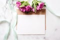 Marble desk with pink flowers, postcard, kraft envelope, twine, cotton branch, invitation card with copy space for your text. Royalty Free Stock Photo