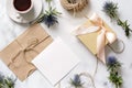 Marble desk with pink flowers, postcard, kraft envelope, twine, cotton branch, invitation card with copy space for your text. Royalty Free Stock Photo