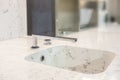 Marble elegant soft shaped square sink with chromium plated water tap. Close up photo with selective focus
