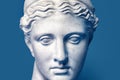 Marble head of young woman, ancient Greek goddess bust isolated on pink background. Gypsum copy of a statue Diana head