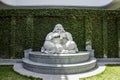 The marble laughing Buddha statues locate on green garden outdoor