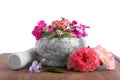 Marble mortar, pestle and different flowers on wooden board against white background Royalty Free Stock Photo